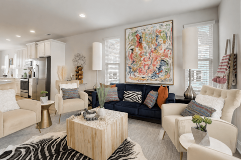 A living room with a large tapestry on the wall and a zebra print rug on the floor.
