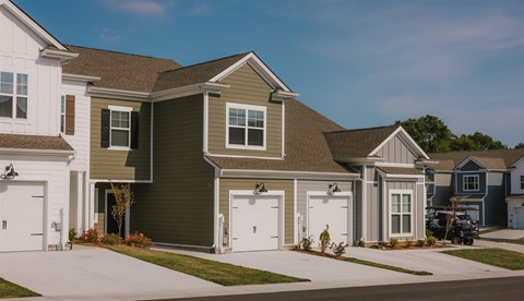 A row of houses with garages on the side.