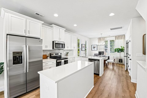 A modern kitchen with stainless steel appliances and white cabinetry.