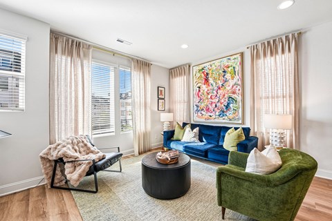 A living room with a blue couch and a green armchair.