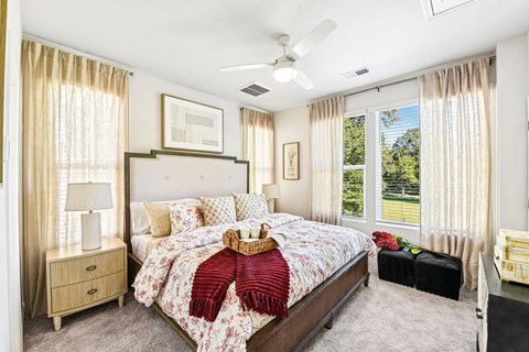 A bedroom with a large bed and a ceiling fan.