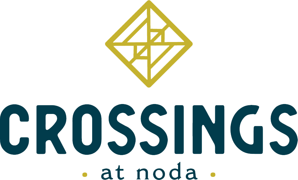 A logo with a diamond shape and the word "CROSSINGS" above it and "at nodal" below it.