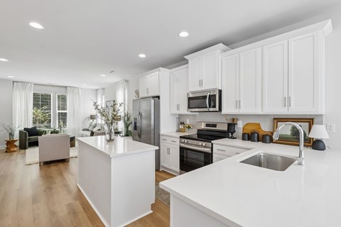 A modern kitchen with white cabinets and appliances.