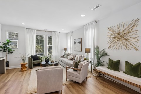A living room with a couch, chairs, and a large decorative piece on the wall.