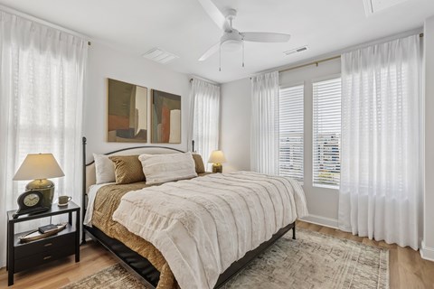 A bedroom with a large bed and a ceiling fan.