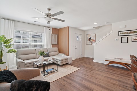 A living room with a couch, a coffee table, and a ceiling fan.