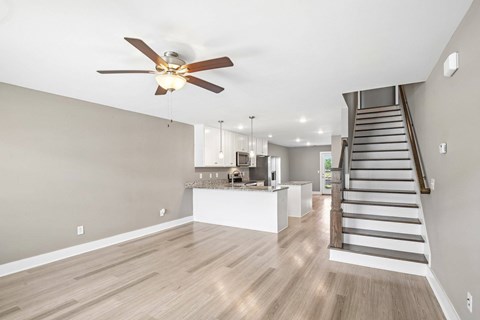 A spacious living room with a staircase leading to the upper floor.