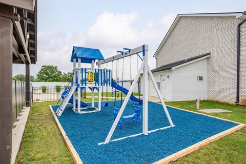A playground with a blue slide and a white frame.