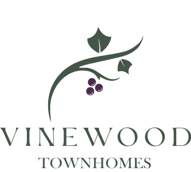 A logo for Vinewood Townhomes with a vine and grapes.