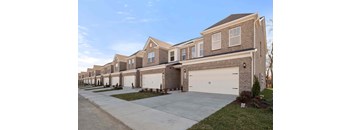 A row of houses with garages in front.