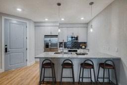 a kitchen with a marble counter top and three bar stools