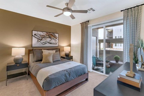 A bedroom with a bed, nightstands, and a ceiling fan.