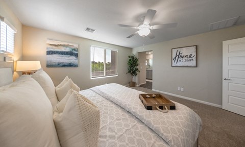 a bedroom with a large bed and a ceiling fan