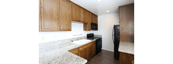 a kitchen with granite countertops and wooden cabinets