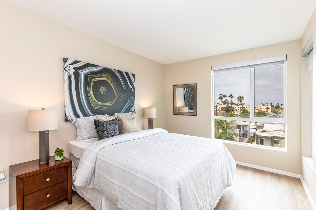 a bedroom with a bed and a large window