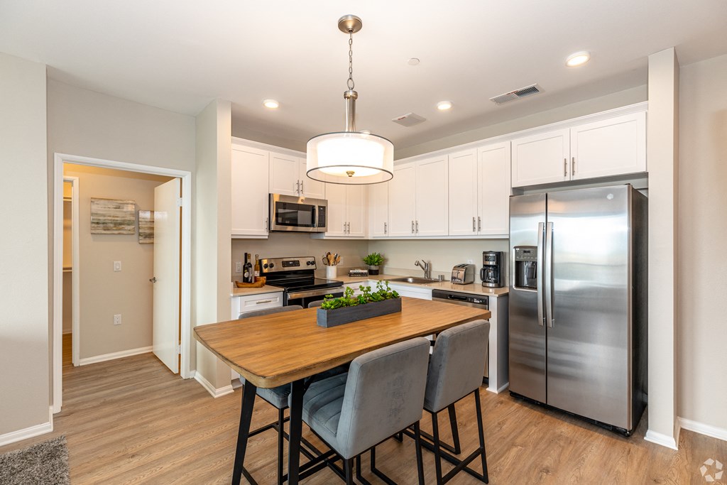 a kitchen with stainless steel appliances and a wooden table