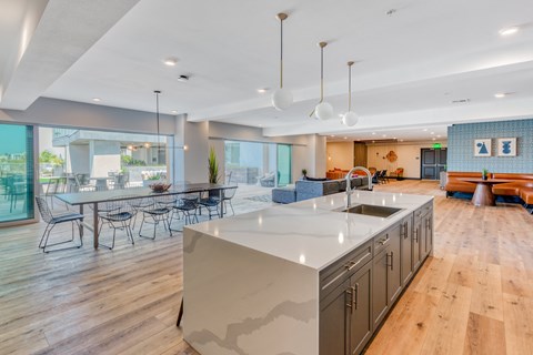 a large kitchen with an island and a dining room with a table and chairs