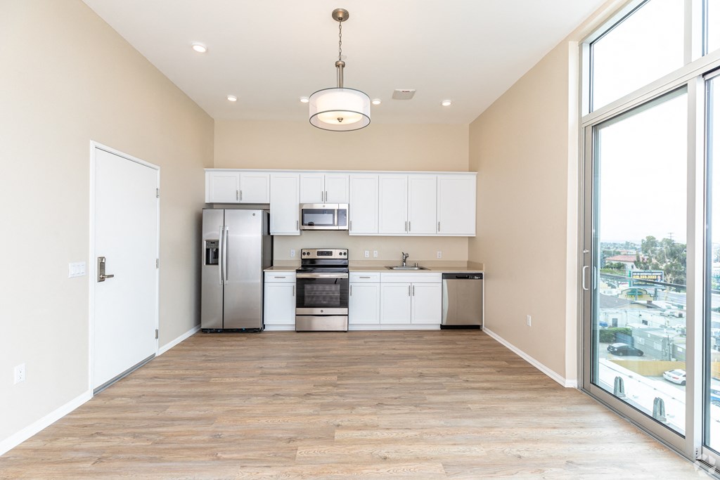 a spacious kitchen with white cabinets and stainless steel appliances