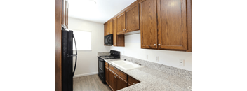 2441 Building Studio kitchen with wooden cabinets and granite counter tops