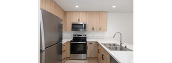 a kitchen with stainless steel appliances and wooden cabinets
