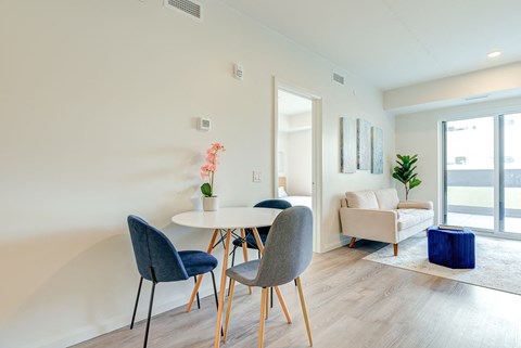A dining room with a white table and blue chairs.