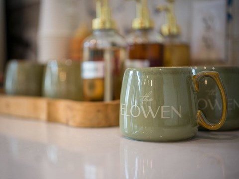A green mug with the word "flowen" written on it.