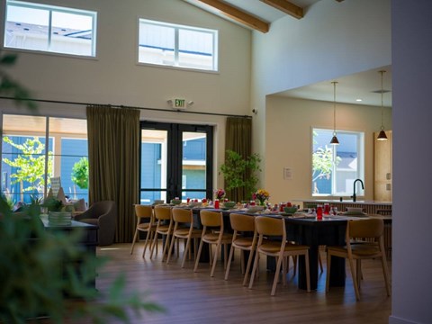 A dining room with a table set for a meal.