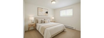 A bedroom with a large bed and a painting on the wall.