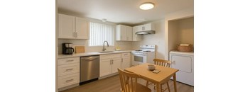 A kitchen with a table and chairs.