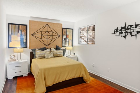 Bedroom with gold bedding and geometric wall art at Skyline at Barton Creek Apartments, Austin