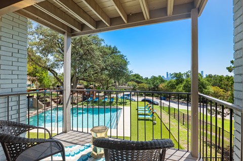 Private balcony overlooking pool and playground at Skyline at Barton Creek Apartments, Texas