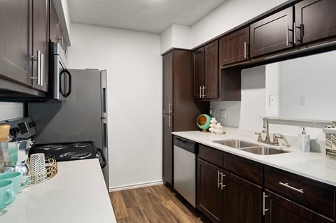 A kitchen with brown cabinets and a white counter.