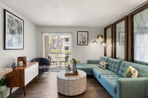 A living room with a blue couch and a wooden table.