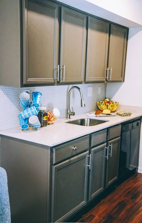 A kitchen with a white counter top and a sink.
