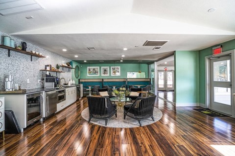 A kitchen with a wooden floor and a dining table with chairs.