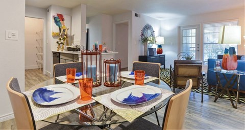 A dining room with a glass table and chairs.