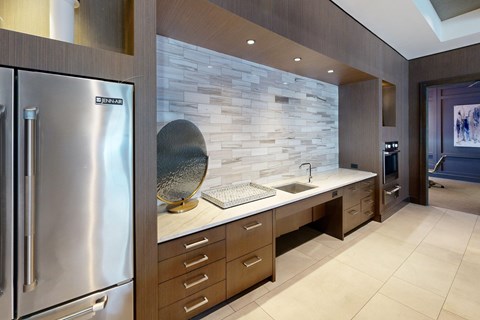 A modern kitchen with a stainless steel refrigerator and wooden cabinets.