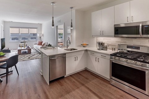 A modern kitchen with stainless steel appliances and white cabinets.