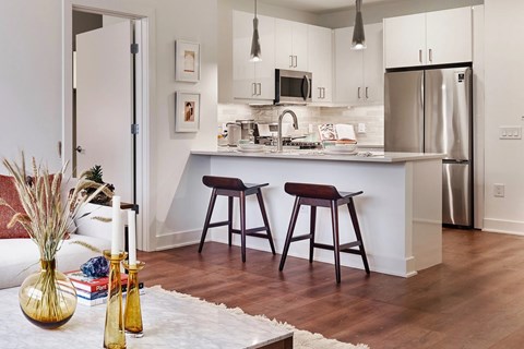 A kitchen with a white counter top and a stainless steel refrigerator.