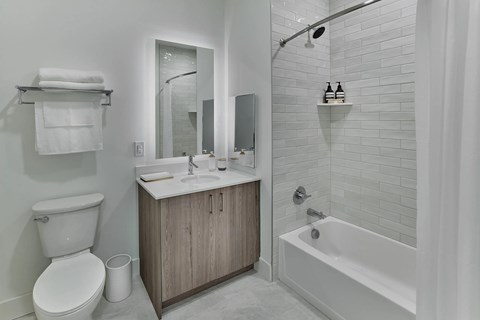 A white bathroom with a toilet, sink, and bathtub.