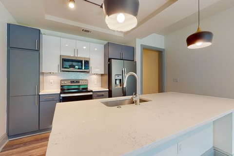 A kitchen with a white counter top and a sink.