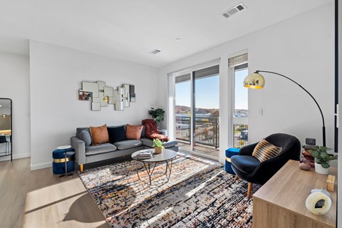 A living room with a grey couch and a black chair.