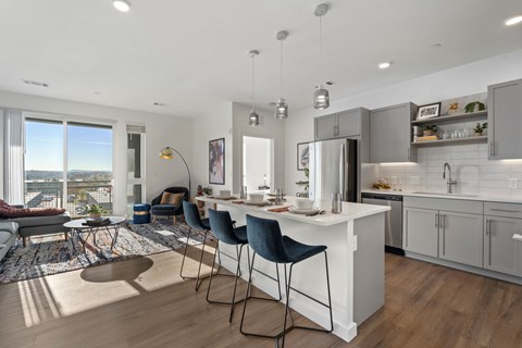 A modern kitchen with a breakfast bar and a view of the city.