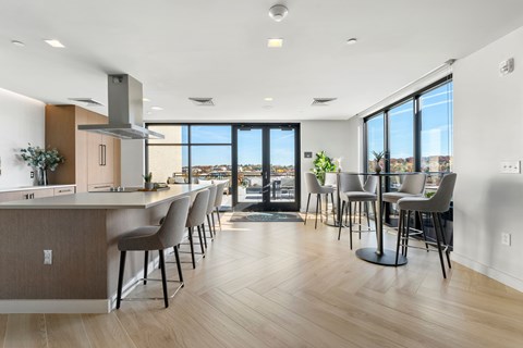 A modern kitchen with a long island and chairs.