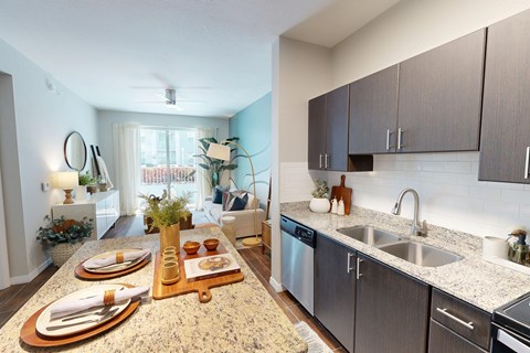 A kitchen with a countertop and a dining table set for two.