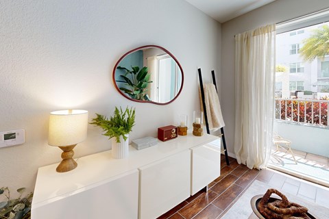 A white lamp sits on a table next to a mirror.