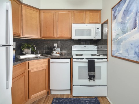 A kitchen with wooden cabinets and white appliances.