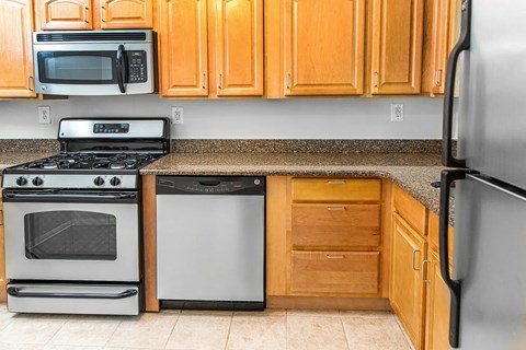 A kitchen with a stove, oven, microwave, and refrigerator.