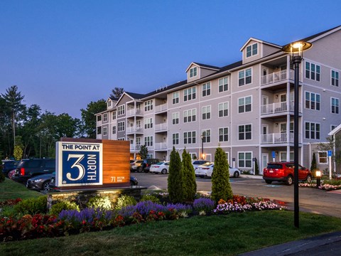 The Point at North apartments are lit up at dusk.