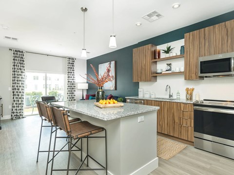 A kitchen with a large island and chairs.